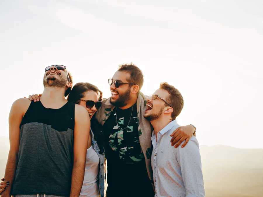A group of friends laughing, arms around each other